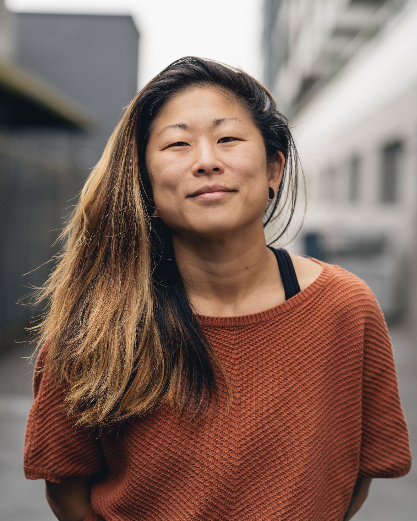 Portrait of Molly Hawkins in a rust knit sweater on a Seattle street