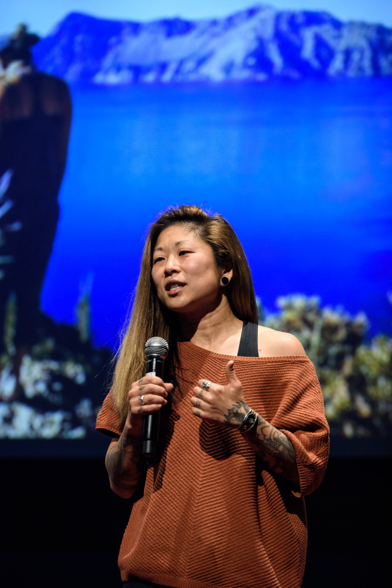 Molly Hawkins speaking on stage with a microphone